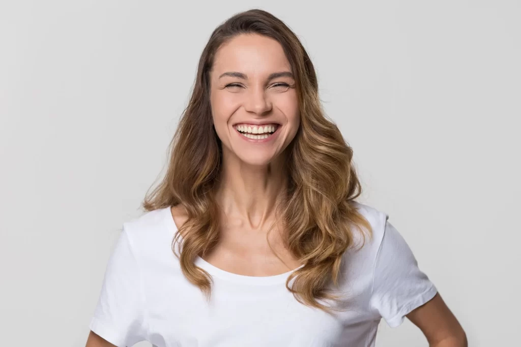 A woman with long hair is smiling for the camera.