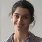 Smiling person with dark hair, blurred background.