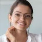 Smiling woman wearing glasses and white shirt.